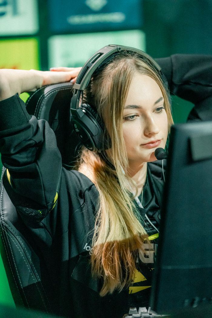 services-03 A dedicated female gamer streaming live with headphones and microphone, immersed in gameplay.