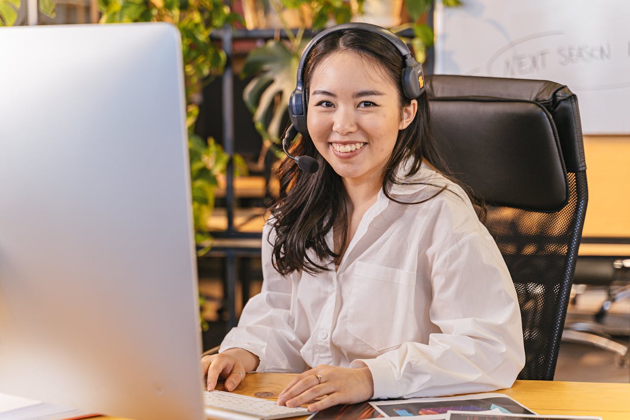 services-02 Businesswoman with headset working at her desk in an office environment.